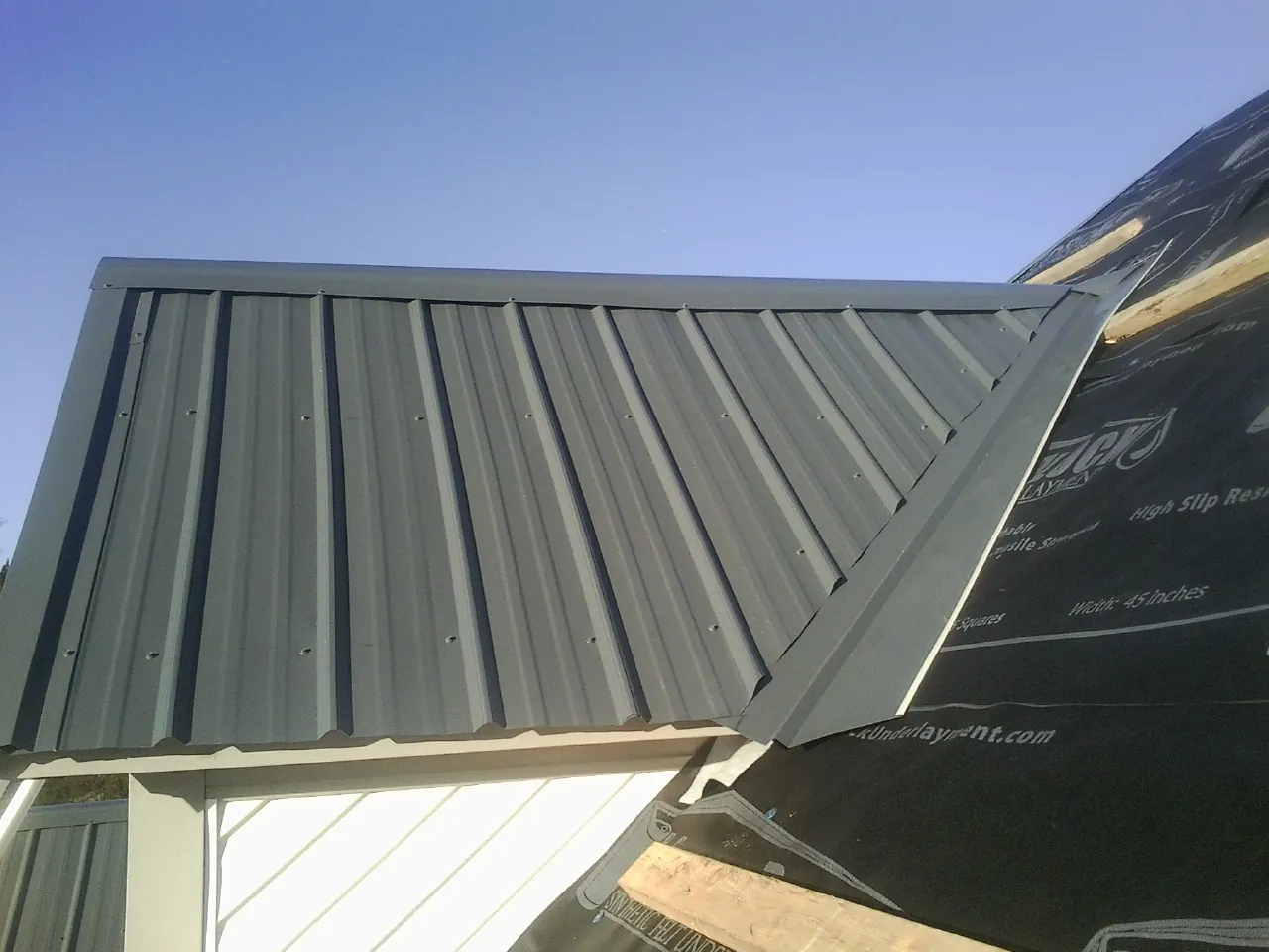 Gray metal roof panels going on over a garage gable in Palmyra